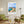 Descriptive Minimalist Malta Poster in Wooden Frame displayed in a living room with green chairs.