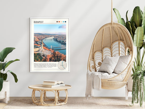 Descriptive Minimalist Budapest Poster in White Frame displayed in a modern living room with a wicker chair.