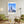 Descriptive Minimalist Chicago Skyline Poster in Wooden Frame displayed in a living room with green chairs.