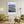 Descriptive Minimalist San Diego Poster in Wooden Frame displayed in a living room with green chairs.