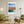 Descriptive Minimalist Malta Poster in Wooden Frame displayed in a living room with green chairs.