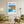 Descriptive Minimalist San Diego Poster in Wooden Frame displayed in a living room with green chairs.