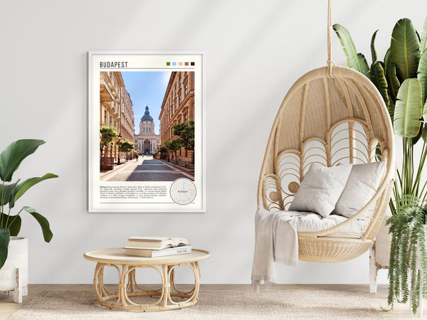 Descriptive Minimalist Budapest Poster in White Frame displayed in a modern living room with a wicker chair.