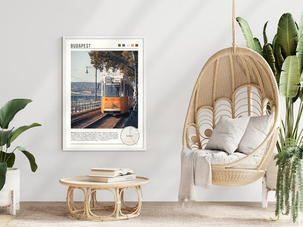 Descriptive Minimalist Budapest Poster in White Frame displayed in a modern living room with a wicker chair.