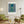 Descriptive Minimalist New York Poster in Wooden Frame displayed in a living room with green chairs.