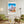 Descriptive Minimalist San Francisco Poster in Wooden Frame displayed in a living room with green chairs.