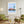 Descriptive Minimalist Boston Poster in Wooden Frame displayed in a living room with green chairs.